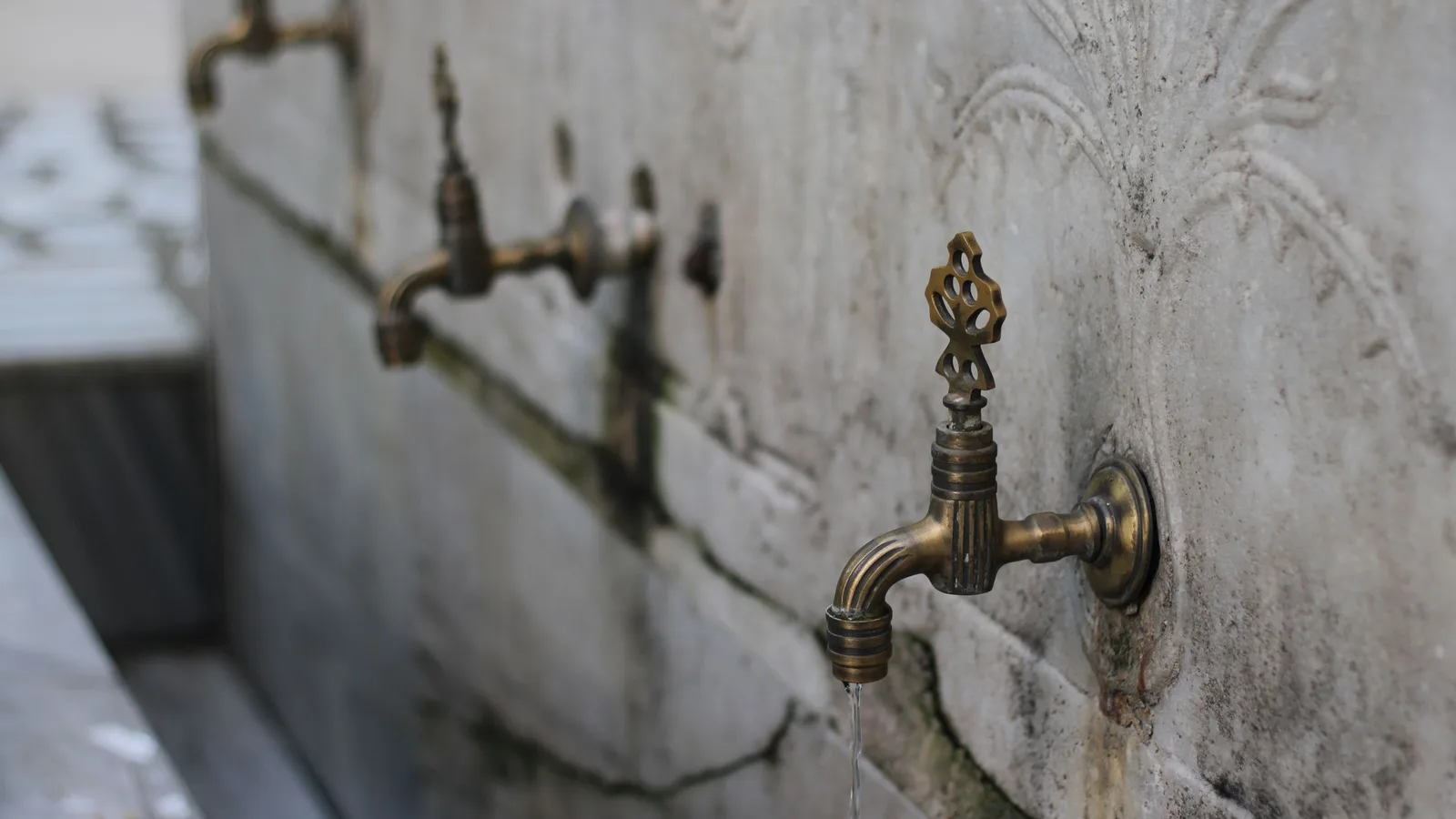 Un robinet en laiton ouvragé dans la salle d’ablutions en marbre d’une mosquée